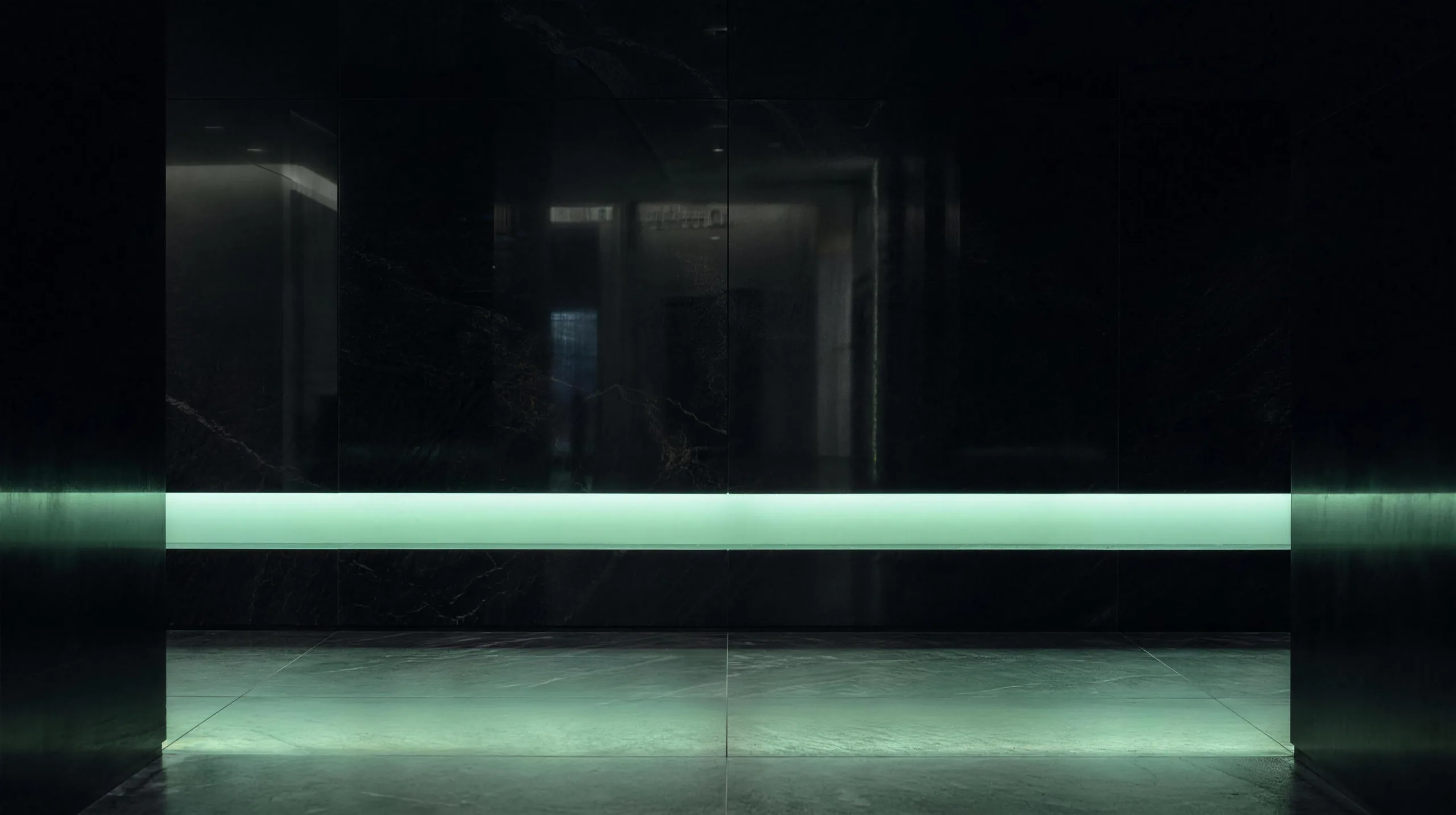 A single horizontal mint light bar spanning a dark stone lobby